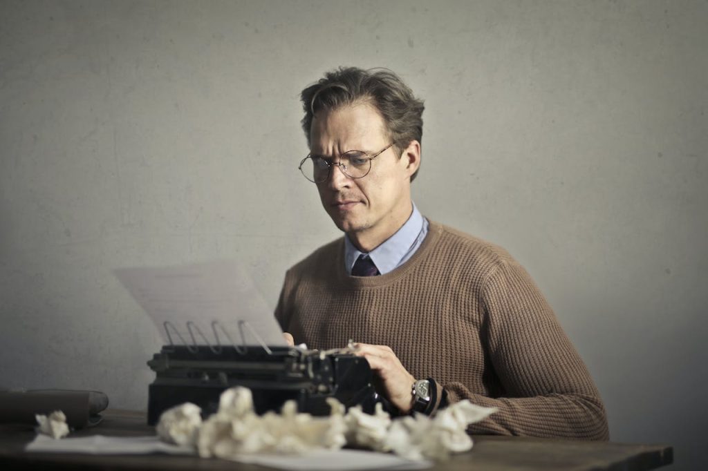 man typing on typewriter carving the writer’s block
